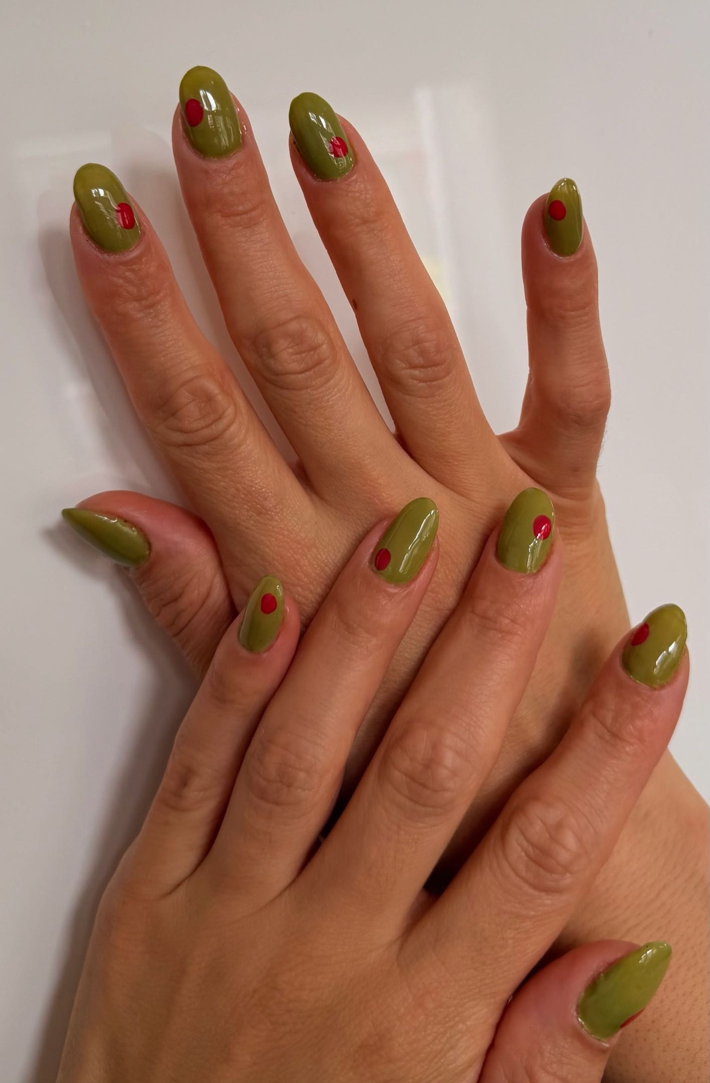 Olive green nails with small red dot design