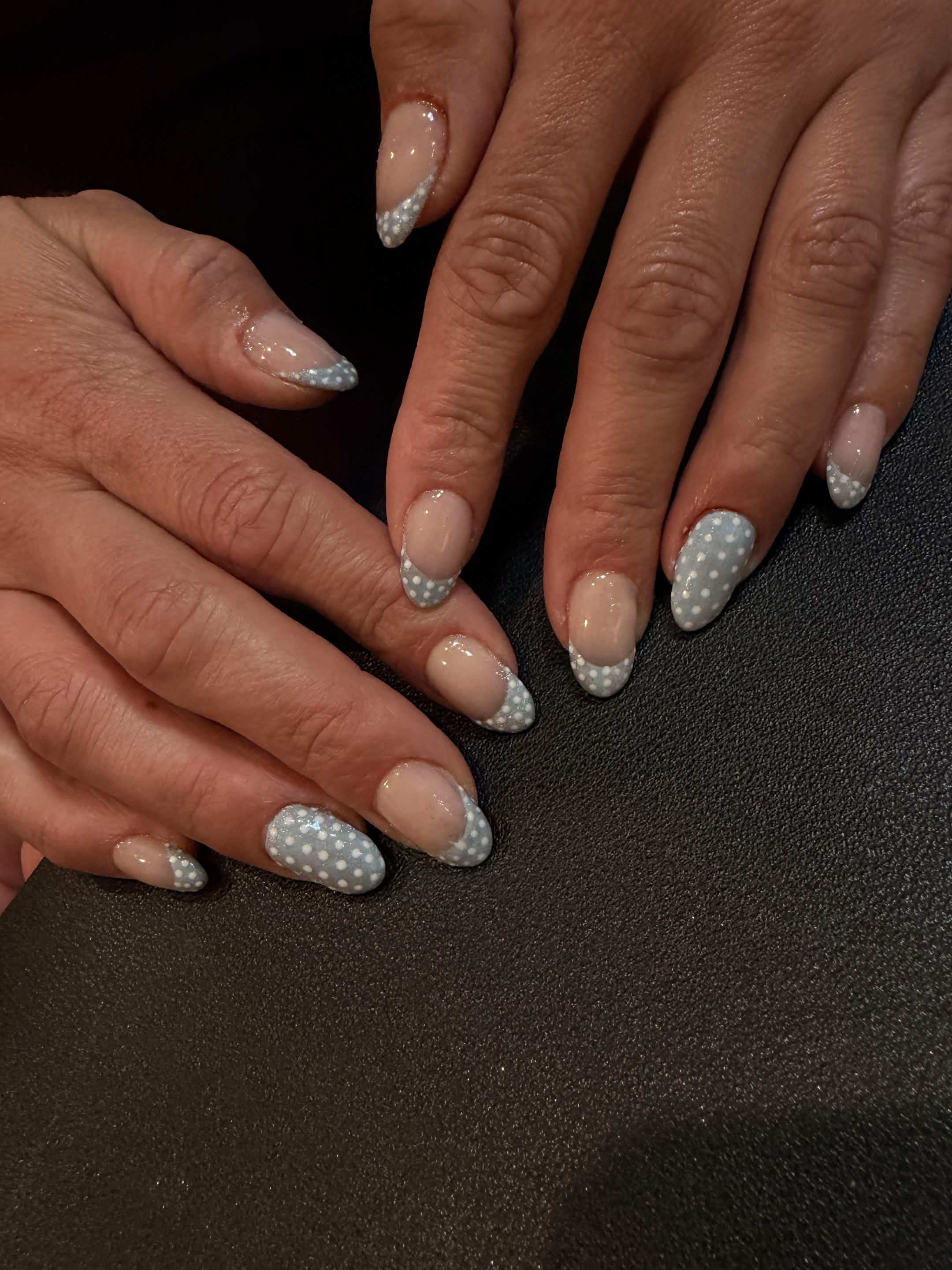 Soft blue polka dot French tips on a sheer nude base